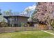 A modern home with a black roof, fenced-in front yard, and fresh landscaping at 1485 S Jasmine Way, Denver, CO 80224