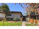 Modern home with wood siding, fresh landscaping, and a walkway leading to the front door at 1485 S Jasmine Way, Denver, CO 80224