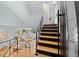 Staircase with black railings and wood stairs leading down to living space filled with natural light at 1485 S Jasmine Way, Denver, CO 80224