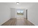 Bright bedroom featuring wood-look flooring and a large window overlooking a landscaped neighborhood at 19817 E 47Th Pl, Denver, CO 80249