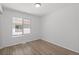 Bright bedroom featuring wood-look flooring and a large window for plenty of natural light at 19817 E 47Th Pl, Denver, CO 80249