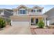 Two-story home with attached two-car garage, neutral siding and green shutters in a residential neighborhood at 19817 E 47Th Pl, Denver, CO 80249
