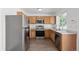 Charming kitchen with stainless steel appliances, wood cabinets, and modern fixtures at 19817 E 47Th Pl, Denver, CO 80249