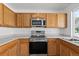 Kitchen area featuring stainless steel appliances, wood cabinetry and modern countertop at 19817 E 47Th Pl, Denver, CO 80249