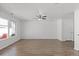 Sunlit living room with wood-look flooring, ceiling fan, and access to the outdoors at 19817 E 47Th Pl, Denver, CO 80249