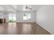 Bright living room with hardwood floors, ceiling fan, and sliding glass doors to the backyard at 19817 E 47Th Pl, Denver, CO 80249