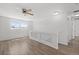 Light-filled loft with wood floors, ceiling fan, and a modern glass railing at 19817 E 47Th Pl, Denver, CO 80249