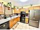 Well-lit kitchen featuring stainless steel appliances, oak cabinets, and stone countertops at 596 Trumbull Ln, Monument, CO 80132