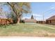 Large backyard with a shed and a mature tree, offering ample space for outdoor enjoyment at 5567 E Asbury Ave, Denver, CO 80222