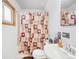 Bathroom featuring a floral shower curtain, sink, and toilet, providing a comfortable space at 5567 E Asbury Ave, Denver, CO 80222