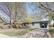 Quaint single story home featuring mature landscaping, a covered parking space, and welcoming front yard at 5567 E Asbury Ave, Denver, CO 80222