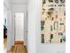 Hallway featuring wood floors, white walls and doors, and a large decorative painting at 5567 E Asbury Ave, Denver, CO 80222
