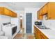A kitchen with wood cabinets, white appliances, and colorful rugs adds character to this cozy home at 5567 E Asbury Ave, Denver, CO 80222