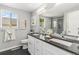 Bright bathroom featuring a double vanity, black countertops, and a stylish tiled shower at 8065 Clay St, Westminster, CO 80031
