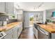 Renovated kitchen with stainless steel appliances, butcher block counters, and access to the outdoor patio at 8065 Clay St, Westminster, CO 80031