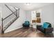 Cozy living area showcasing dark hardwood floors, comfortable seating, and a staircase to upper level at 8065 Clay St, Westminster, CO 80031