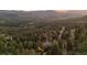 Expansive mountain range and forest, showcasing home in the landscape at sunset at 394 S Ponderosa Way, Evergreen, CO 80439