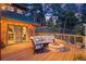 Inviting deck with outdoor seating, a fire pit, and string lights offering a cozy ambiance for evening relaxation at 394 S Ponderosa Way, Evergreen, CO 80439