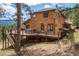 View of the wood-clad home's deck featuring a hot tub and mountain views in the background at 394 S Ponderosa Way, Evergreen, CO 80439