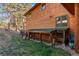 Angled view of home exterior with outdoor animal enclosure and green lawn space at 394 S Ponderosa Way, Evergreen, CO 80439