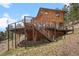Back of the house displaying an elevated deck with stairs and metal cable railing at 394 S Ponderosa Way, Evergreen, CO 80439