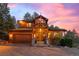 Stunning craftsman home with an attached garage, stone accents, a charming front porch and beautiful outdoor lighting at 394 S Ponderosa Way, Evergreen, CO 80439
