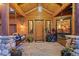 Inviting front porch with a wooden door, a porch swing, and stone pillars at 394 S Ponderosa Way, Evergreen, CO 80439