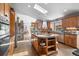 Spacious kitchen featuring a central island, granite counters, stainless steel appliances, and a stunning stone fireplace at 394 S Ponderosa Way, Evergreen, CO 80439
