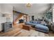 Cozy living room with hardwood floors, sectional sofa, and stairs in the background at 394 S Ponderosa Way, Evergreen, CO 80439