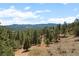 Scenic landscape view showing mountain range in distance with tree-filled foreground at 394 S Ponderosa Way, Evergreen, CO 80439