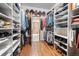 Organized walk-in closet with custom shelving and hardwood floors, providing ample storage space for clothing and accessories at 394 S Ponderosa Way, Evergreen, CO 80439