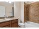 Bathroom with granite countertop, dark wood cabinets, and tiled shower at 13986 Lexington Dr, Parker, CO 80134