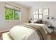 Comfortable bedroom featuring a large window with bright sunlight, art decorations and neutral tones at 13986 Lexington Dr, Parker, CO 80134