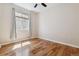 Bedroom features hardwood floors, a ceiling fan, and a large window for natural light at 13986 Lexington Dr, Parker, CO 80134