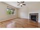 Cozy living room featuring hardwood floors, a fireplace, and a large window with natural light at 13986 Lexington Dr, Parker, CO 80134