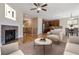 Open-concept living room featuring a fireplace, hardwood floors, and seamless flow to the kitchen at 13986 Lexington Dr, Parker, CO 80134