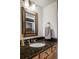 Elegant bathroom with granite countertops, a decorative mirror, and stylish fixtures at 1 Sedgwick Dr, Cherry Hills Village, CO 80113