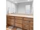 Bathroom vanity with double sinks, wood cabinets, and granite countertops at 1 Sedgwick Dr, Cherry Hills Village, CO 80113