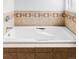 Relaxing white bathtub with stylish tile surround and chrome fixtures, perfect for a soothing soak at 1 Sedgwick Dr, Cherry Hills Village, CO 80113