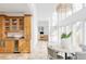 Bright kitchen adjacent to dining room with custom cabinetry, stone countertops, and modern appliances at 1 Sedgwick Dr, Cherry Hills Village, CO 80113