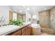 Bright bathroom with a glass-enclosed shower, soaking tub, and dual vanity at 396 E Warren Ave, Denver, CO 80210