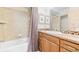 Well-lit bathroom features a shower and tub combination with elegant decor and wooden vanity at 396 E Warren Ave, Denver, CO 80210