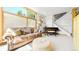 Bright living room with a leather sofa, an ottoman, and a baby grand piano at 396 E Warren Ave, Denver, CO 80210