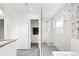 Beautiful bathroom features a shower with glass enclosure, white tiling, and mosaic tiled floor at 3540 Pecos St, Denver, CO 80211