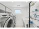 Functional laundry room with modern appliances, storage shelving, and a sink at 3540 Pecos St, Denver, CO 80211