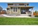 Home backyard featuring green siding, a well-kept lawn, a covered patio, a hot tub and new concrete at 16188 Elizabeth St, Thornton, CO 80602
