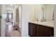 Bright bathroom view from vanity featuring a shower with curtain, tile floors, and bedroom beyond at 16188 Elizabeth St, Thornton, CO 80602