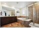 Bathroom featuring a soaking tub, glass shower, double sink vanity, and tiled floors at 16188 Elizabeth St, Thornton, CO 80602