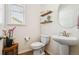 A half-bathroom features a pedestal sink, decorative shelving, and stylish decor at 16188 Elizabeth St, Thornton, CO 80602
