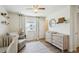 Bedroom with wood-look floors, dresser, a crib, and natural light at 16188 Elizabeth St, Thornton, CO 80602